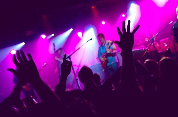 A crowd cheers for a band playing at Belly Up Aspen, a live music venue in Aspen, CO.
