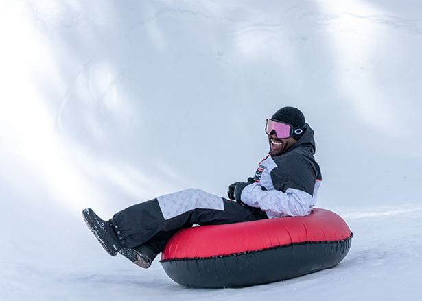 Man enjoys a tubing experience at Aspen Snowmass, at Winter tubing