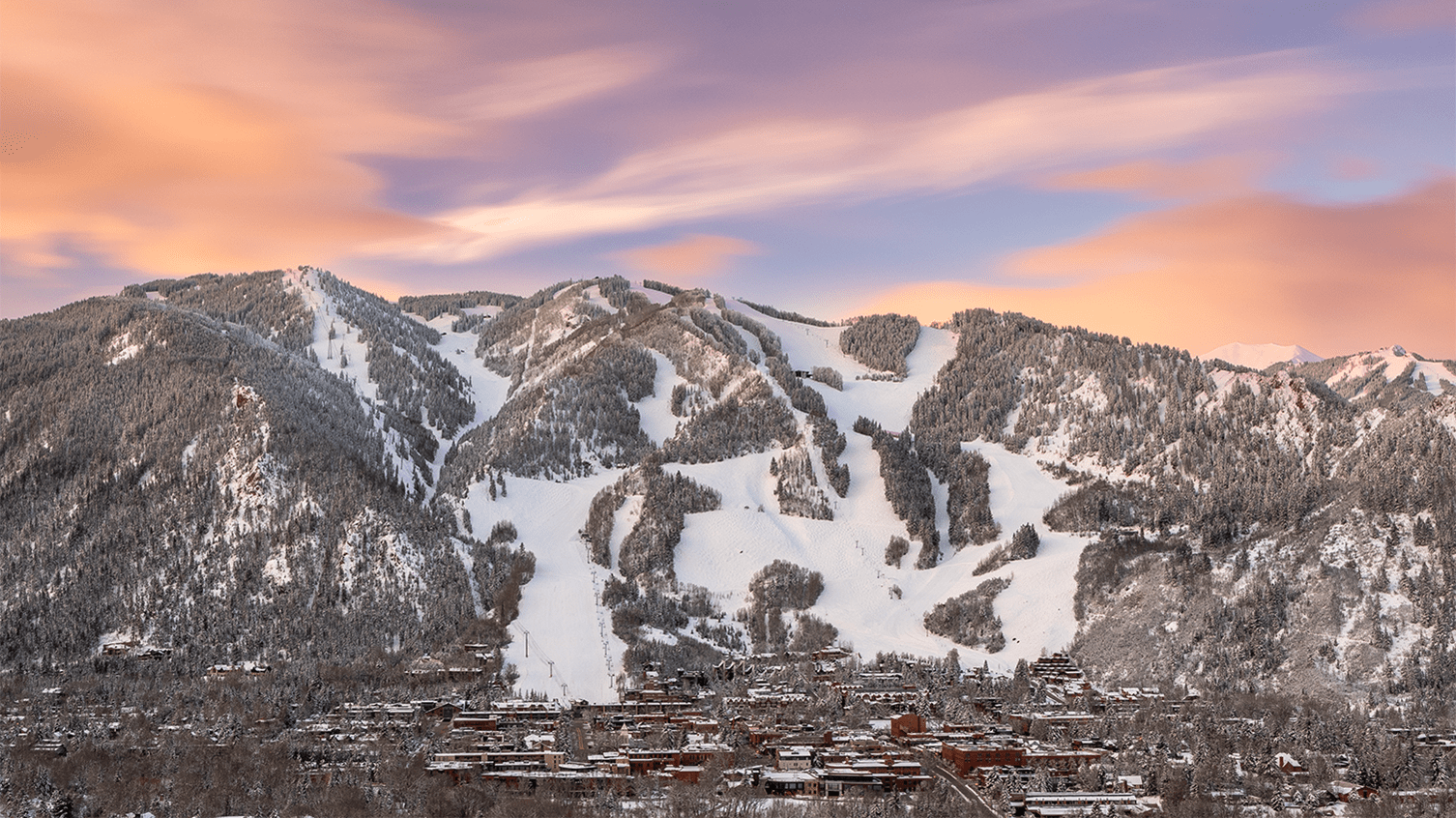 Pink and purple sky over Aspen Mountain and the town on a winter day
