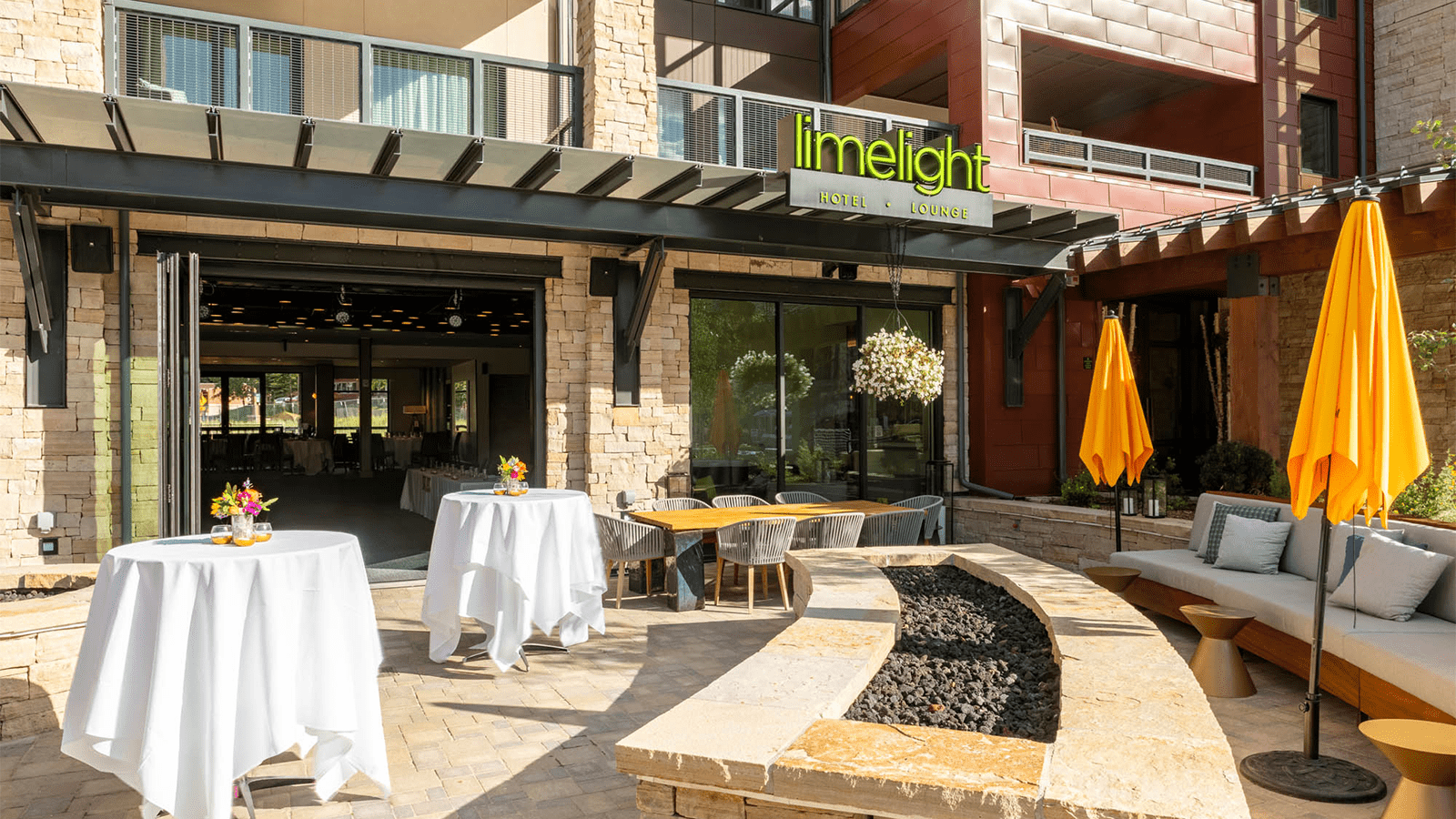Exterior view of outdoor reception area, fancy tables set up on outdoor patio at Limelight Snowmass