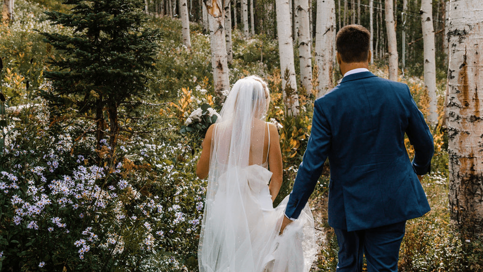 a bride and groom walking though the forest at Snowmass for some time alone