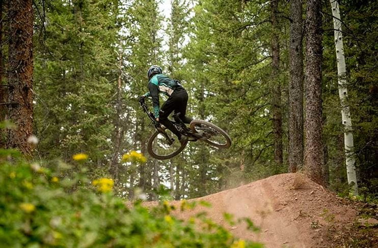 Pulling a trick on a trail at Snowmass Bike Park