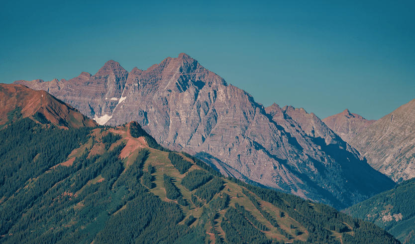 Aspen Highlands in the summer, blue skies over green rocky peaks