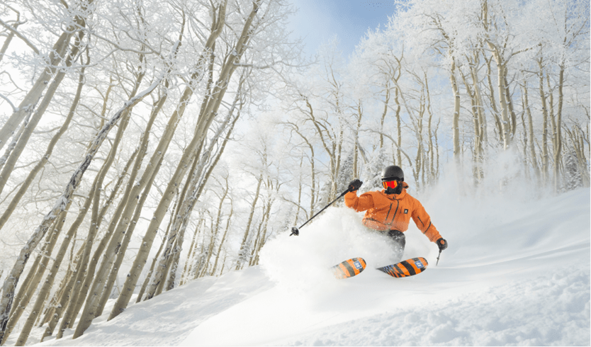 Skier shreds through white snowy trees at Aspen Snowmass